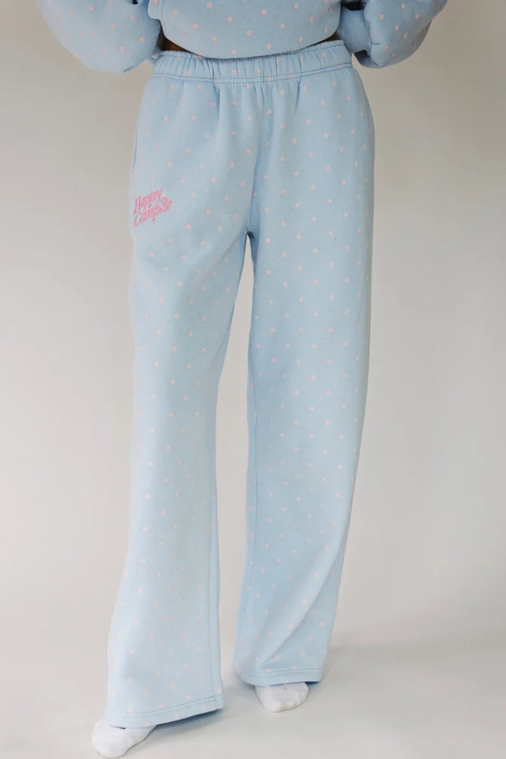 Light blue fleece lounge pants with a small pink script logo on the left thigh, featuring a subtle pink polka dot pattern and elastic waistband.