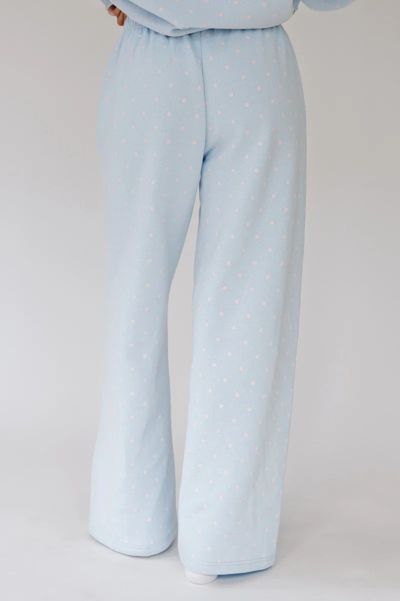 Light blue wide-leg pajama pants with a small white polka dot pattern, shown on a model from the waist down against a light gray background.