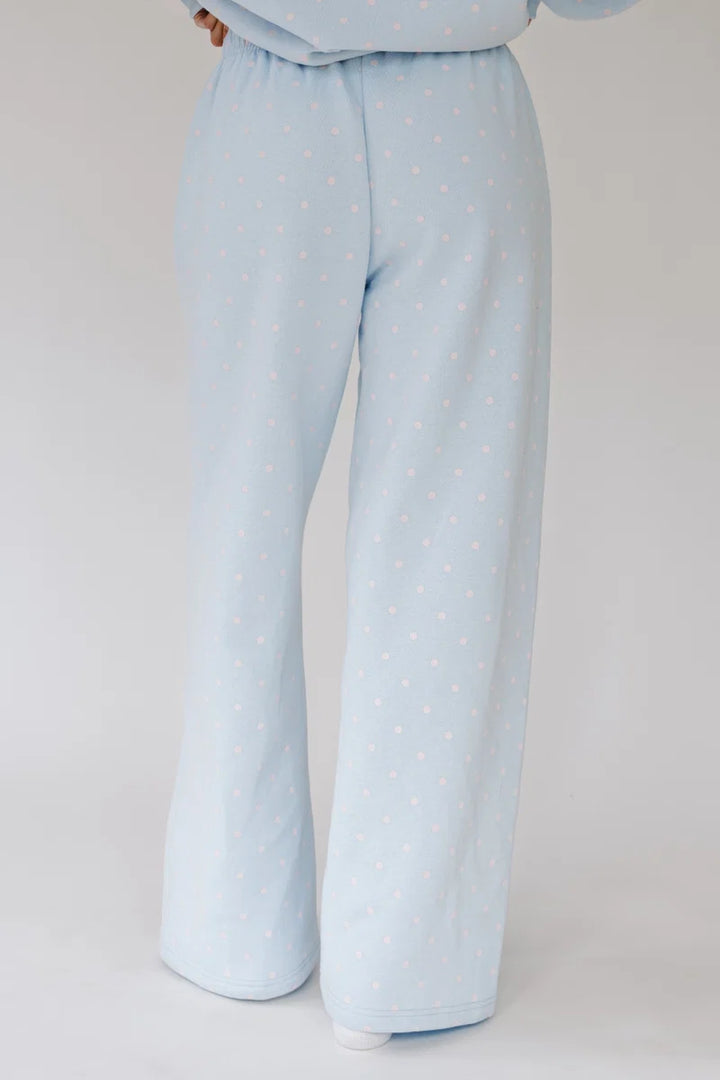 Light blue wide-leg pajama pants with a small white polka dot pattern, shown on a model from the waist down against a light gray background.