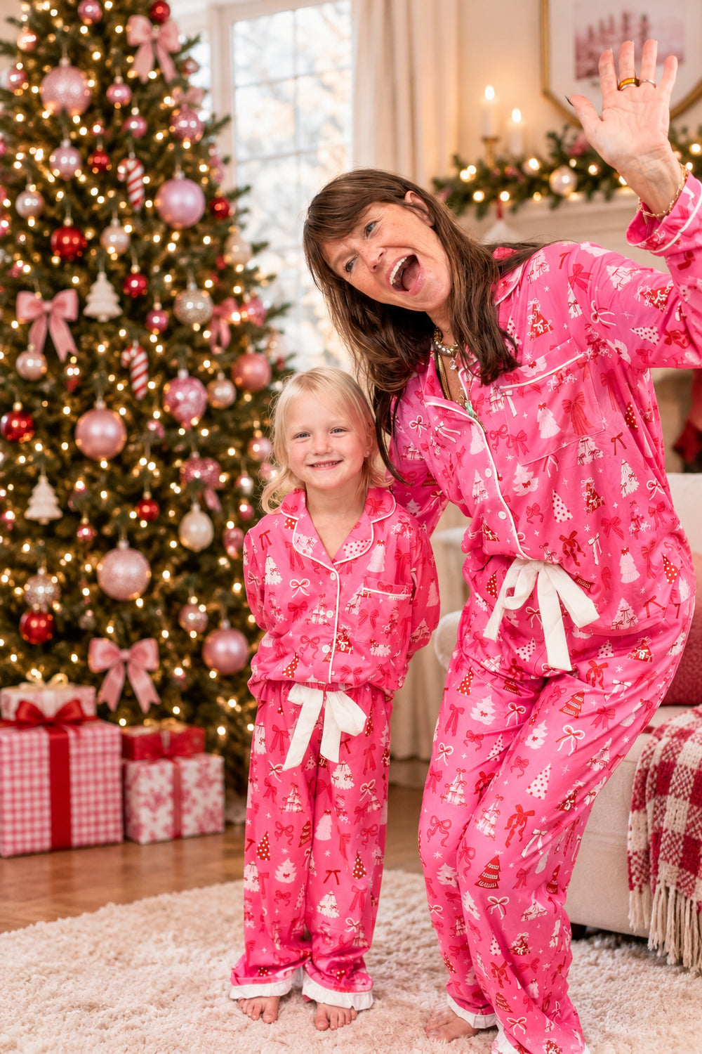 Woman and child wearing matching christmas pajamas on plain background
