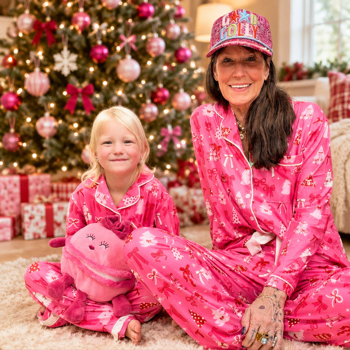 Woman and child wearing matching christmas pajamas on plain background
