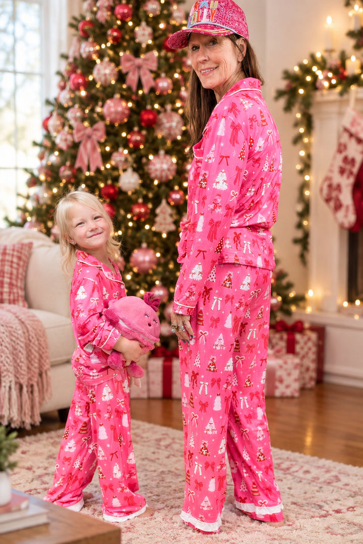 Woman and child shown from back wearing matching christmas pajamas on plain background