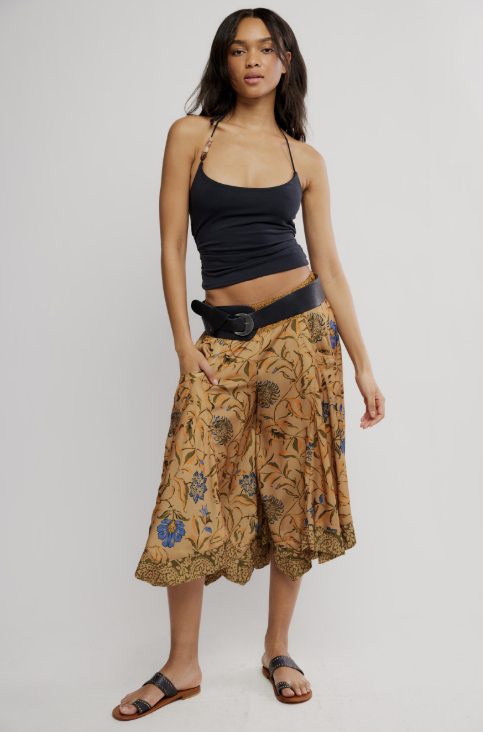 Woman wearing a black top and patterned skirt on a white background