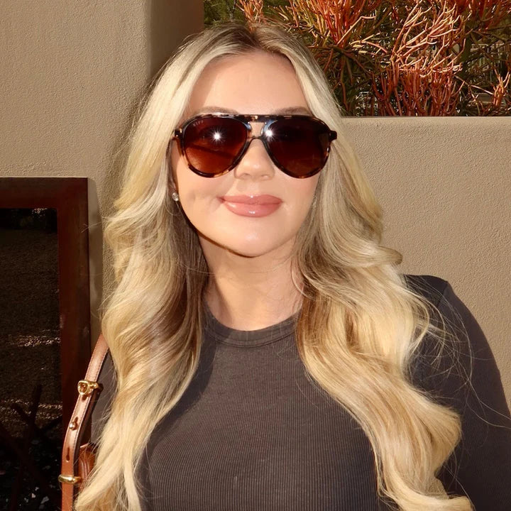 Woman wearing sunglasses with a neutral background