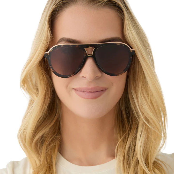 Woman wearing a pair of sunglasses with a neutral background