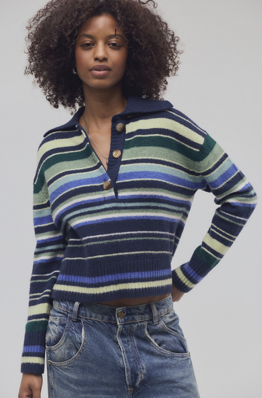 Woman wearing blue and green stripe sweater and jeans on white background