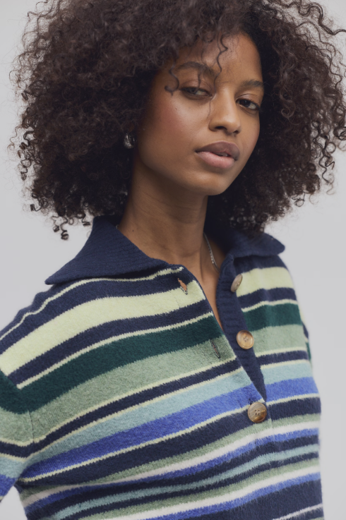 Woman wearing blue and green stripe sweater on white background