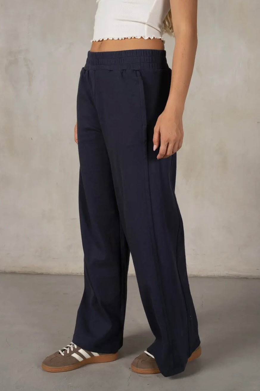 Person wearing navy wide-leg pants against a neutral background