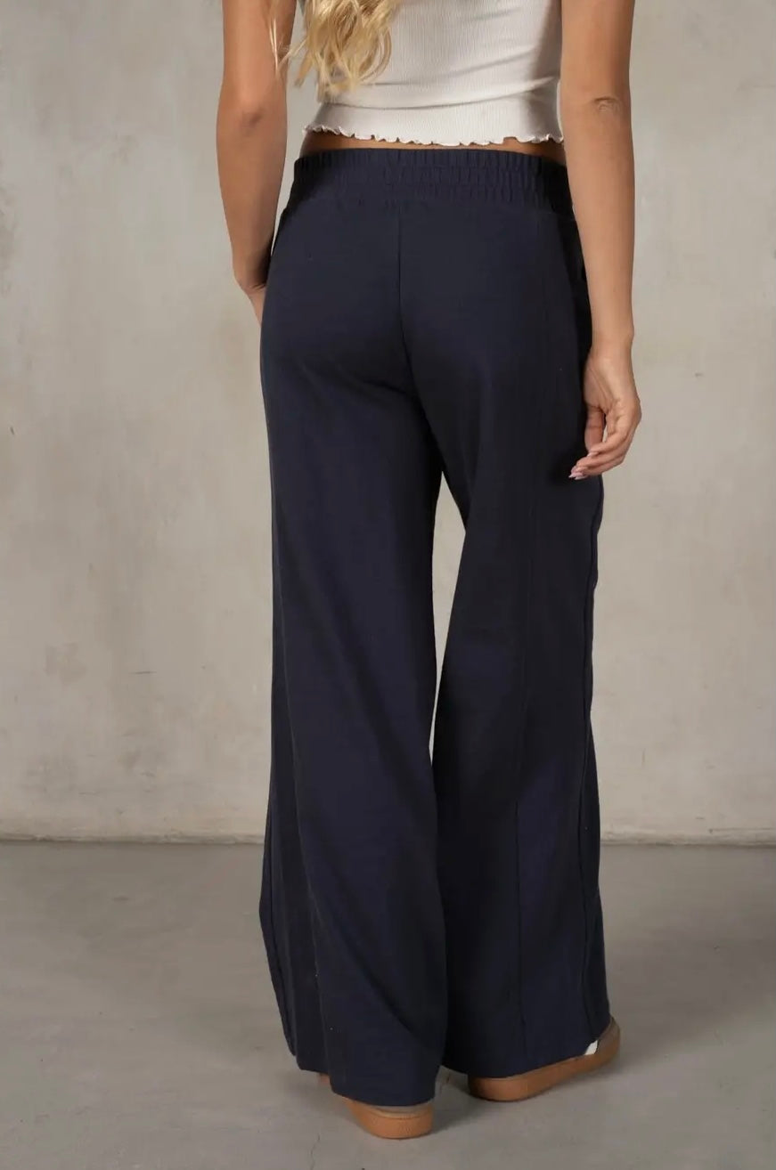 Navy wide-leg pants worn by a person against a neutral background