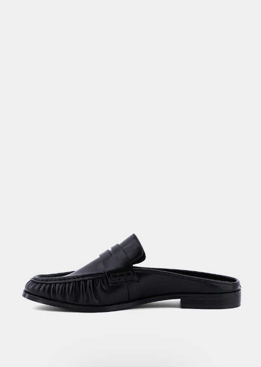 A single black leather loafer-style mule slipper shown in side profile against a plain light gray background.