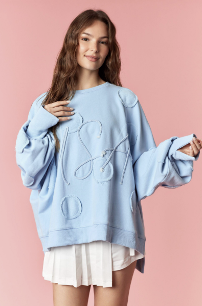Woman wearing light blue pullover and white skirt on pink background