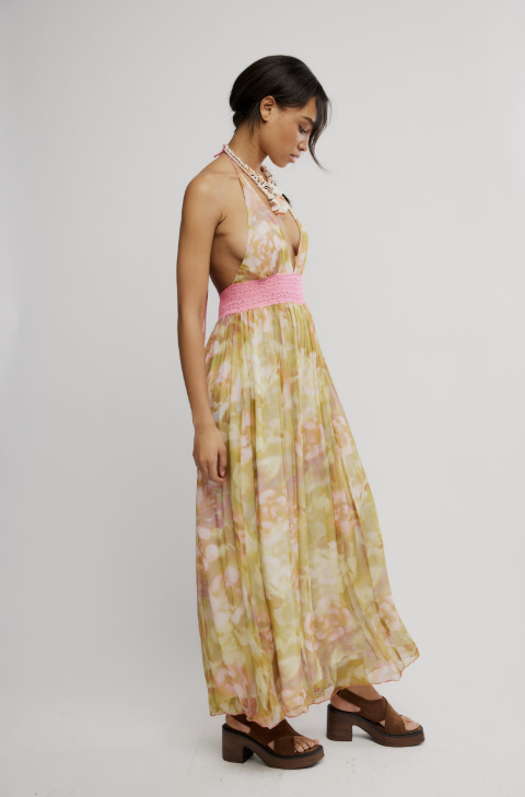 Woman wearing a floral jumpsuit with a pink top on a white background