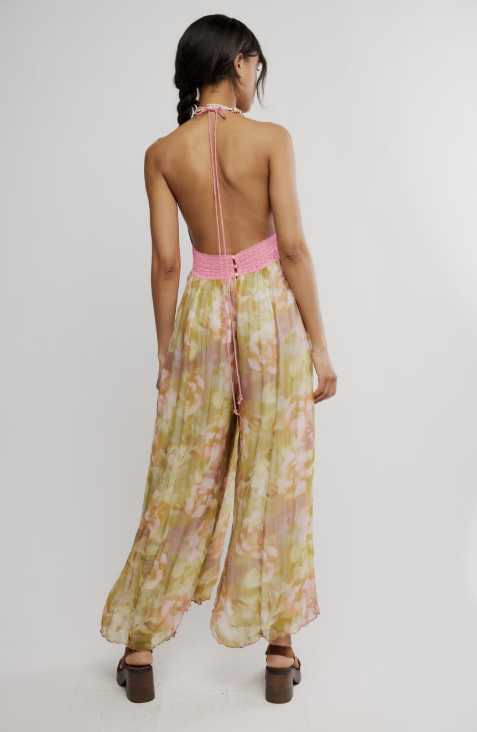Woman wearing a floral jumpsuit with pink straps on a white background