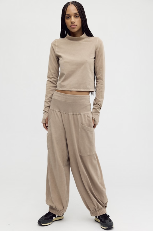 Woman wearing beige matching set on plain background