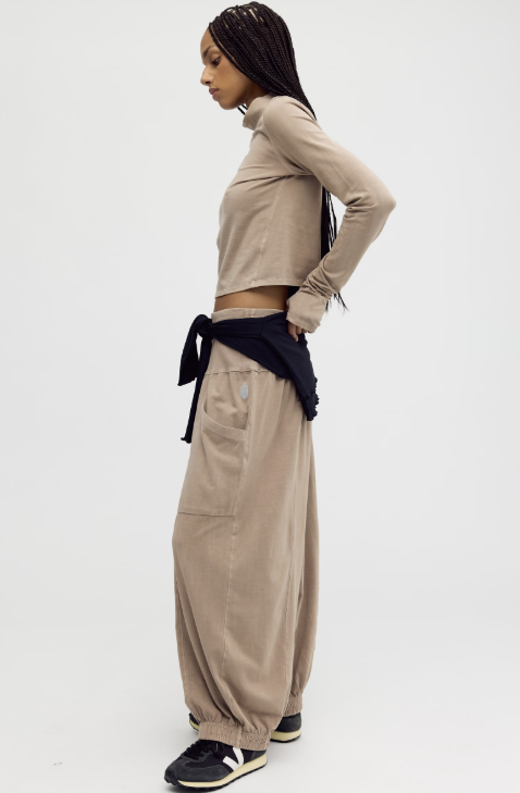 Woman shown from side view wearing matching beige set on plain background