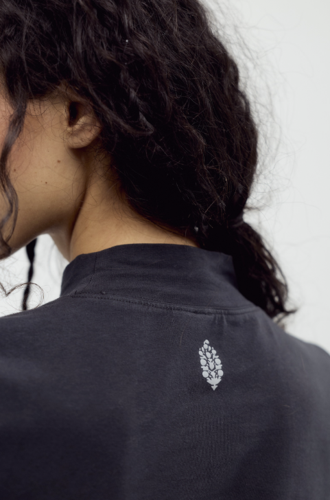 Woman wearing black shirt with logo on white background