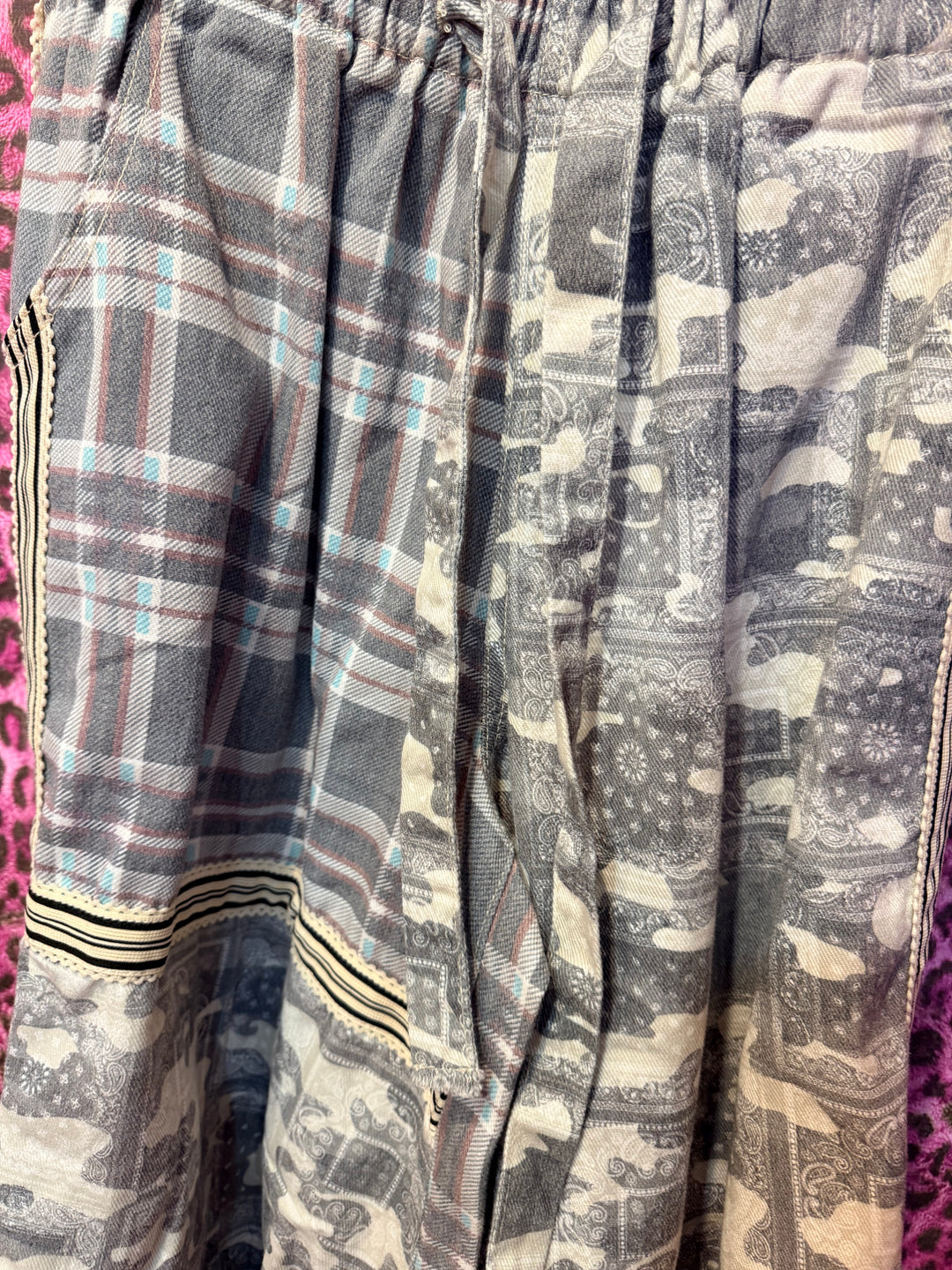Plaid fabric with a pattern of black, white, and gray on a pink background
