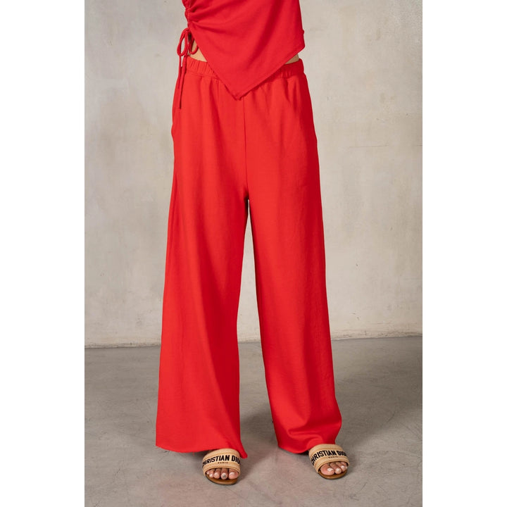 Red pants worn by a person on a plain background