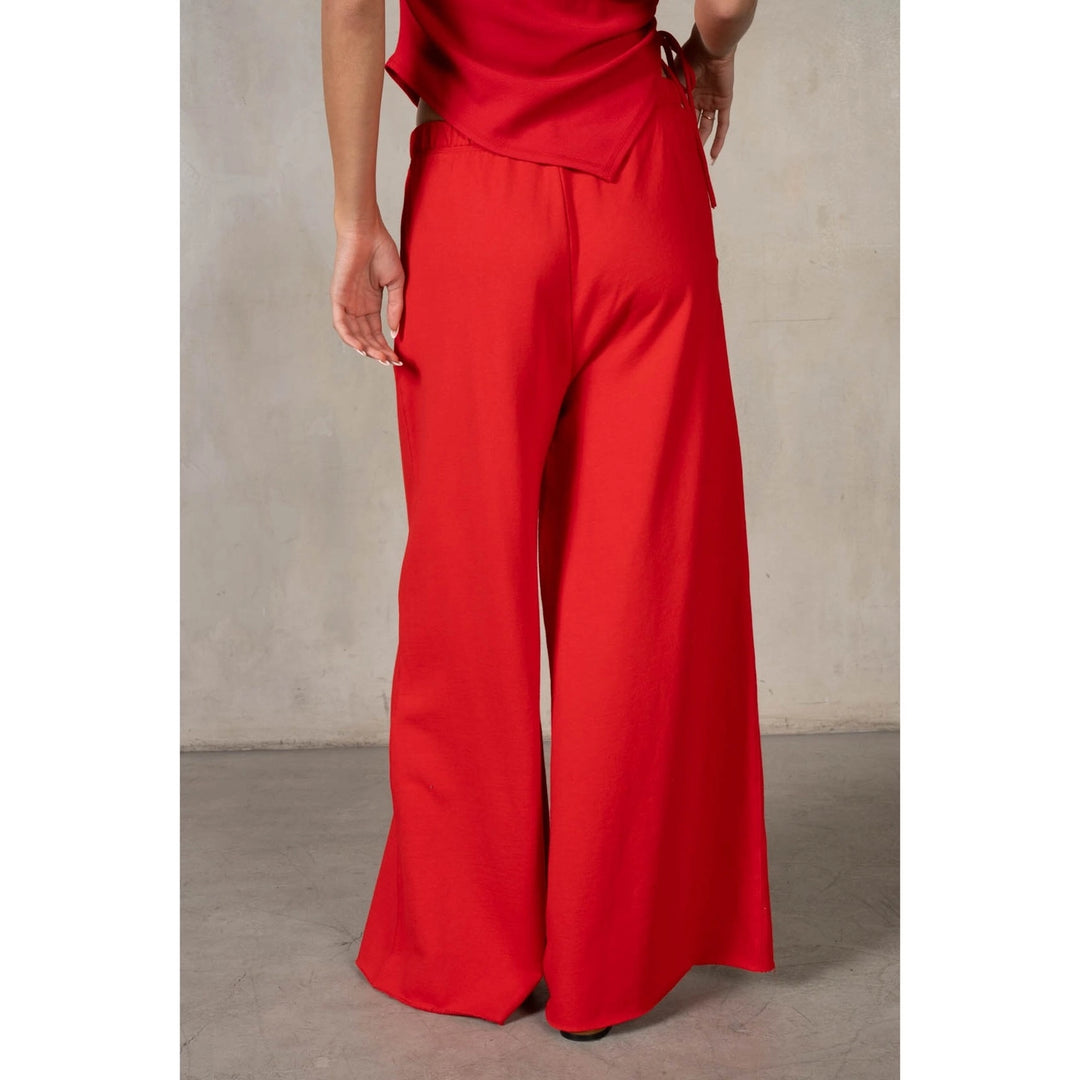 Red wide-leg pants worn by a person on a neutral background