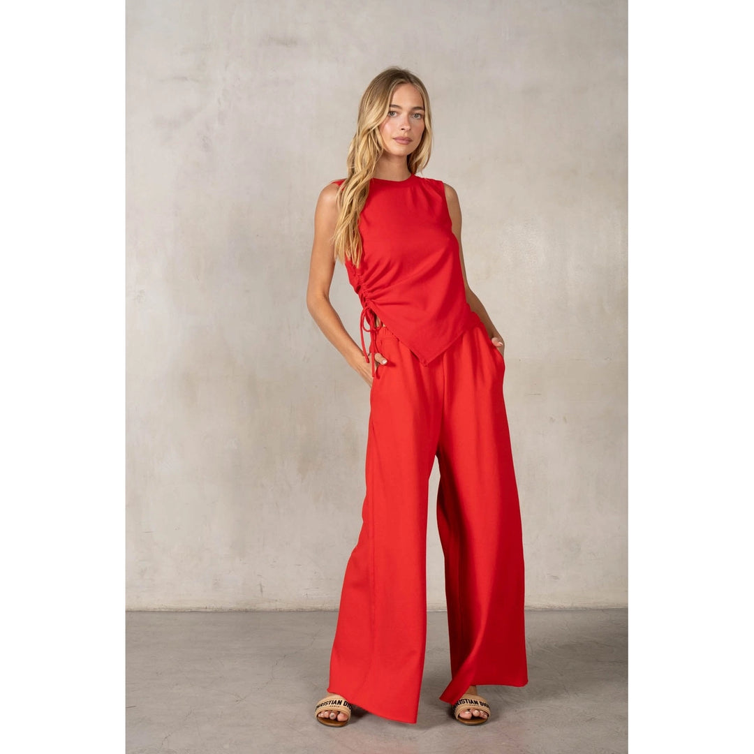 Woman wearing a red jumpsuit against a plain background