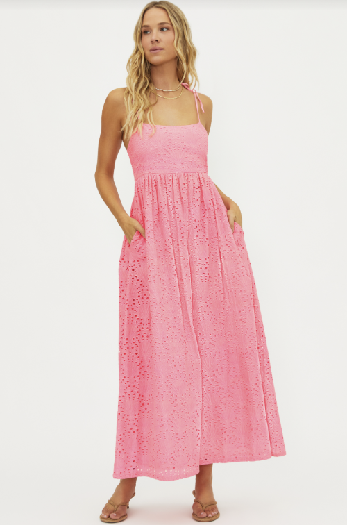 Woman wearing pink eyelet maxi dress on white background