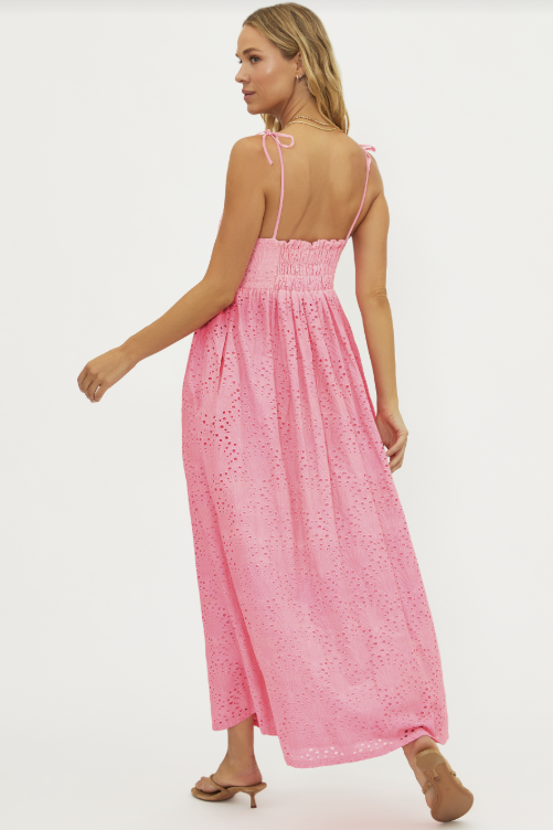 Woman wearing a pink lace dress on a white background
