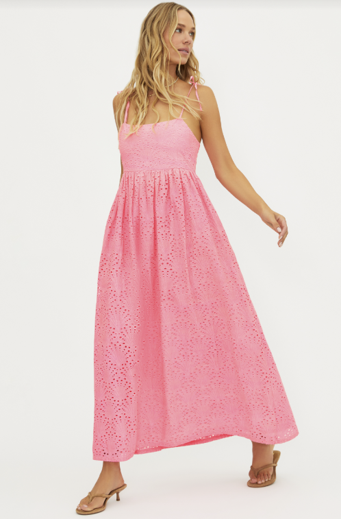 Woman wearing a pink lace dress on a white background