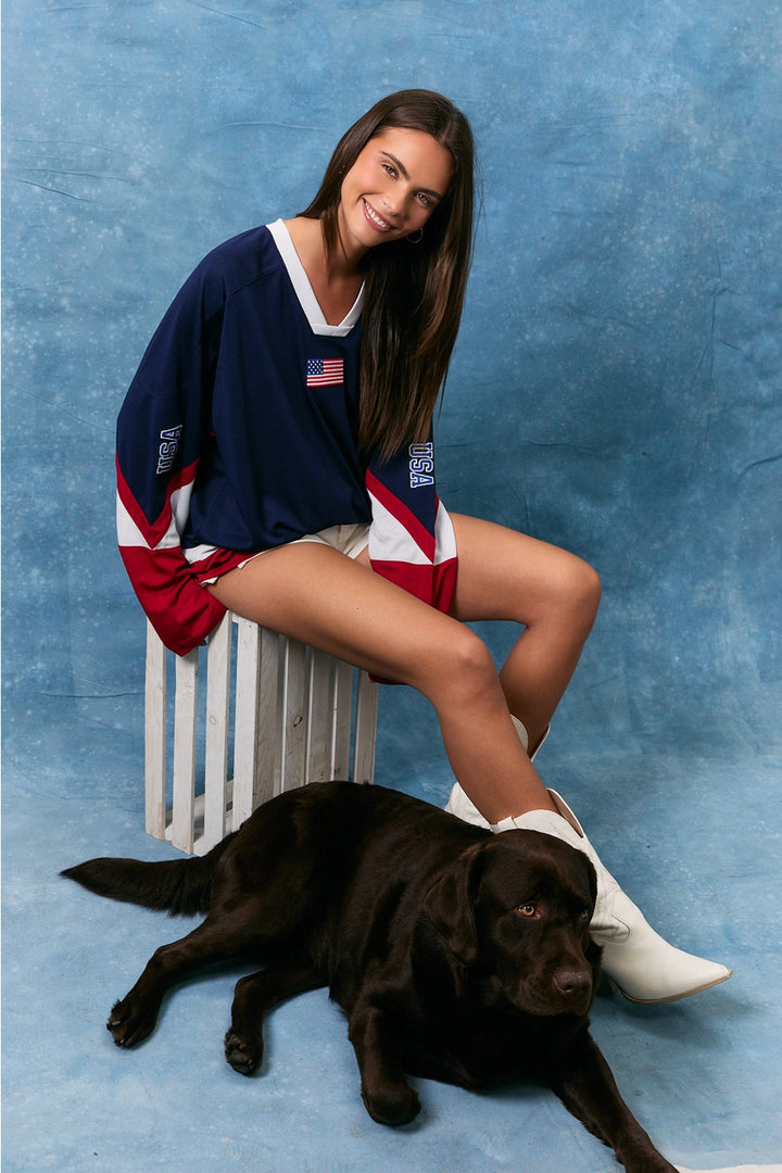Woman in a sports jersey with a dog on a blue background