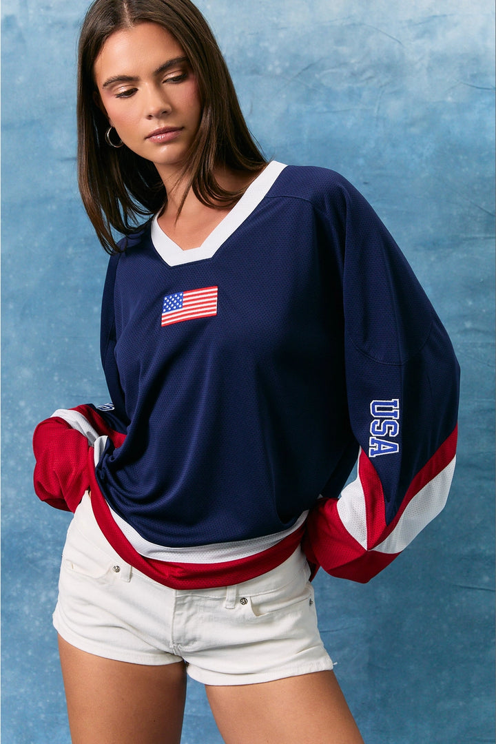 Woman wearing a blue sports jersey with an American flag and &