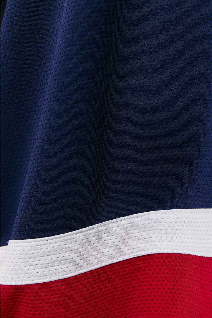 Close-up of a sports jersey with blue, white, and red colors.