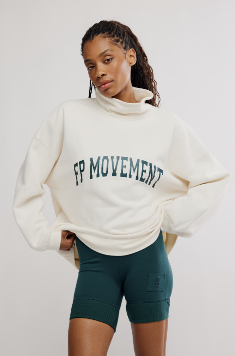 Woman wearing ivory sweatshirt with &