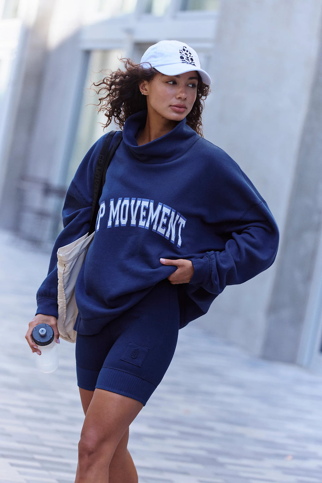 Woman wearing navy mock neck sweatshirt with &