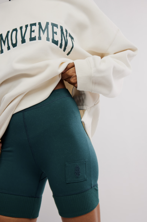 Close up of woman wearing ivory sweatshirt and green shorts