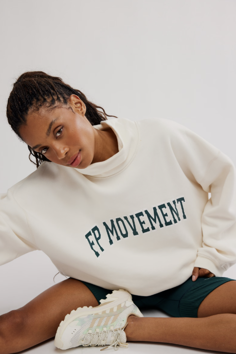 Woman wearing ivory sweatshirt and green shorts