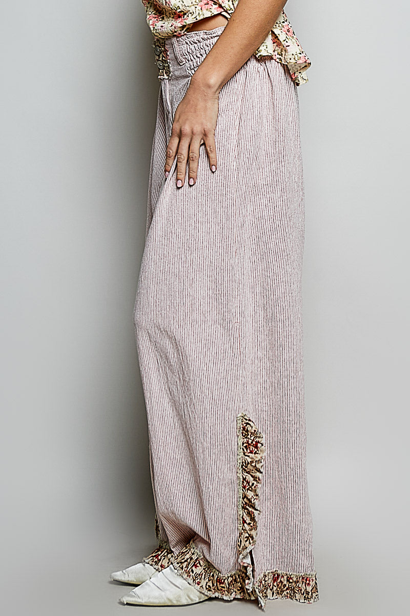 Long light-colored skirt with floral embroidery at the bottom on a plain background