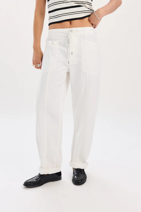 Person wearing white pants and black shoes on a white background