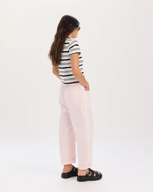 Person wearing a striped shirt and pink pants on a white background