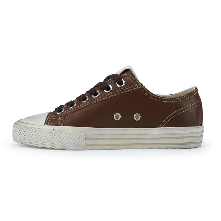 Chocolate brown slip-on shoe with white sole on a light gray background