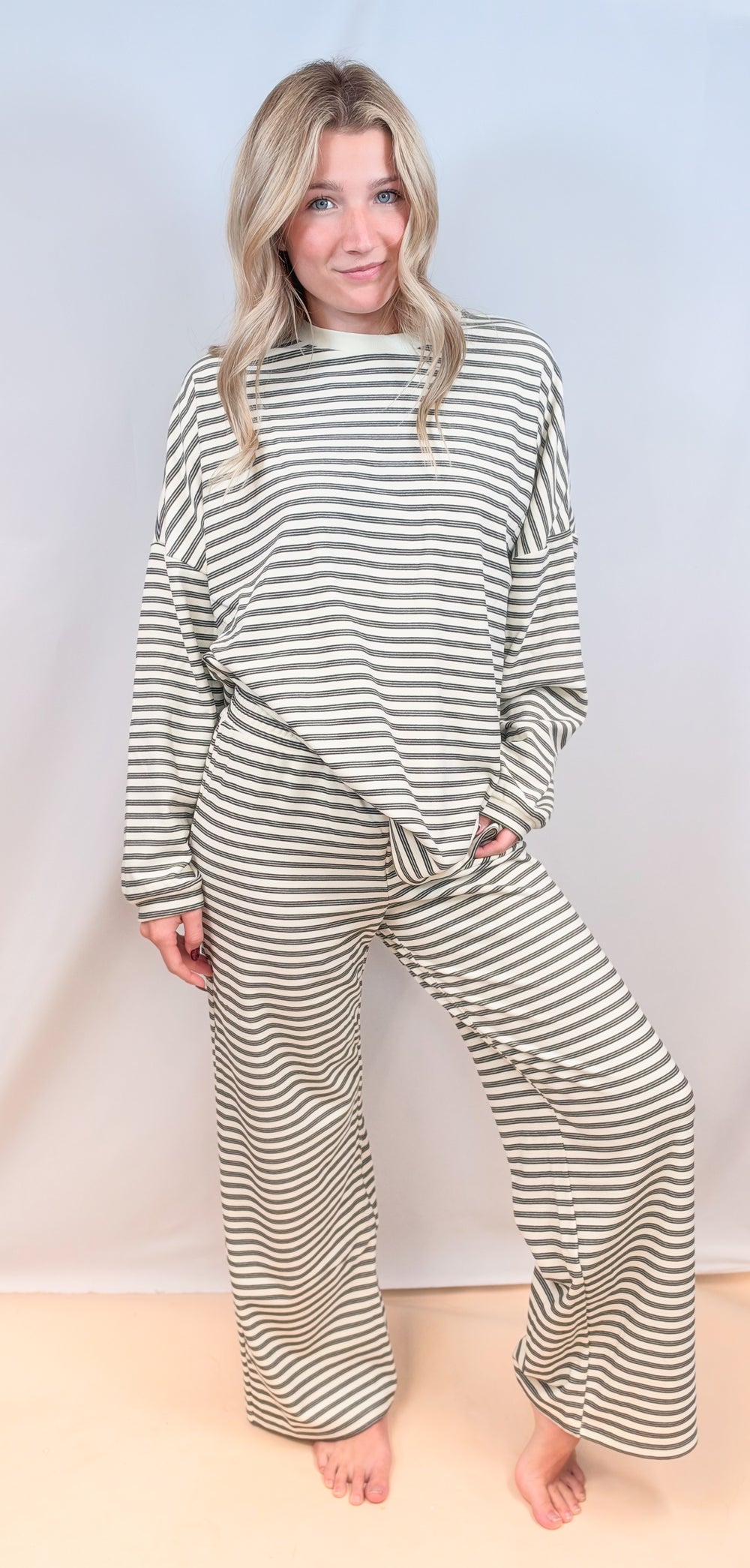 Woman wearing matching cream stripe set on plain background