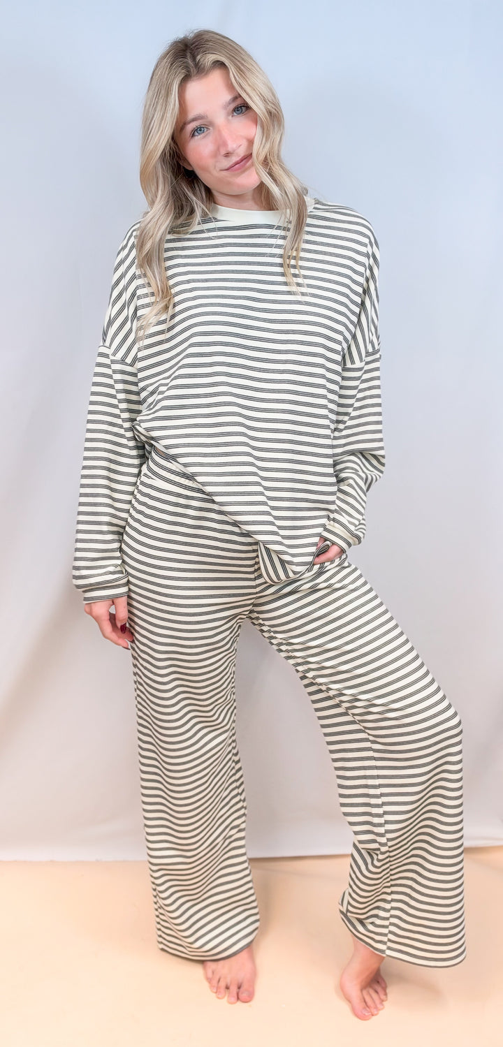 Woman wearing matching cream stripe set on plain background