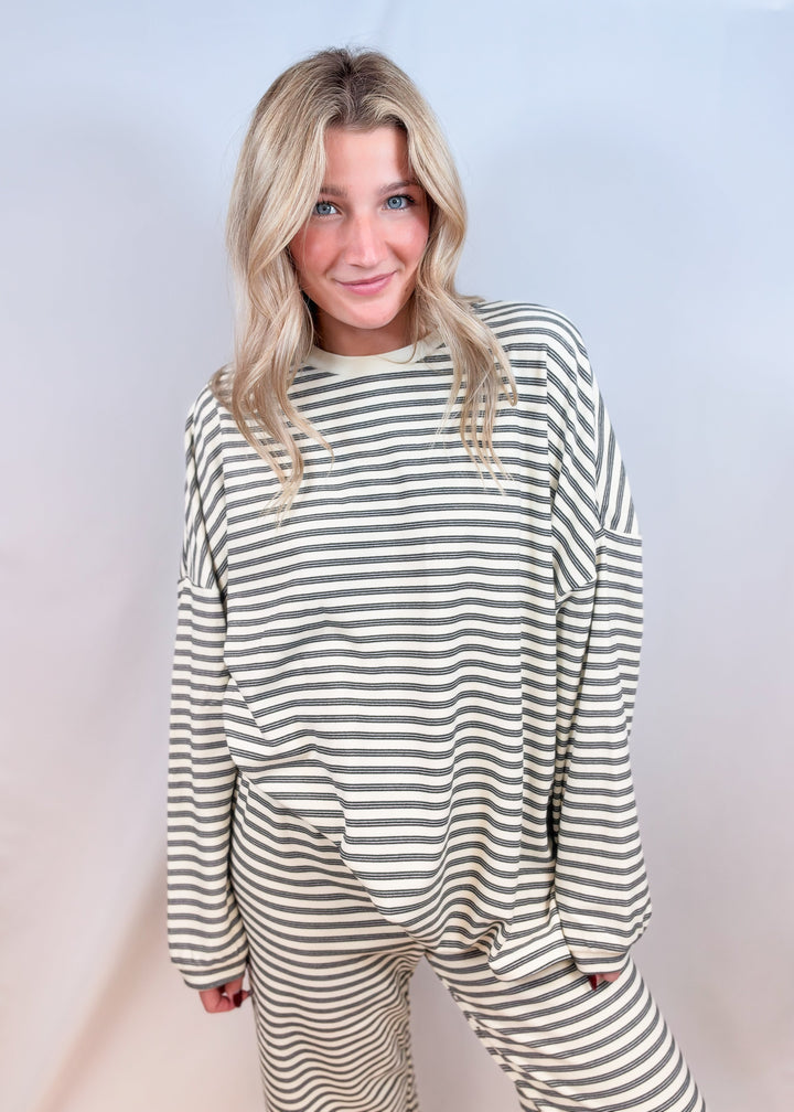 Woman wearing cream stripe matching set on plain background