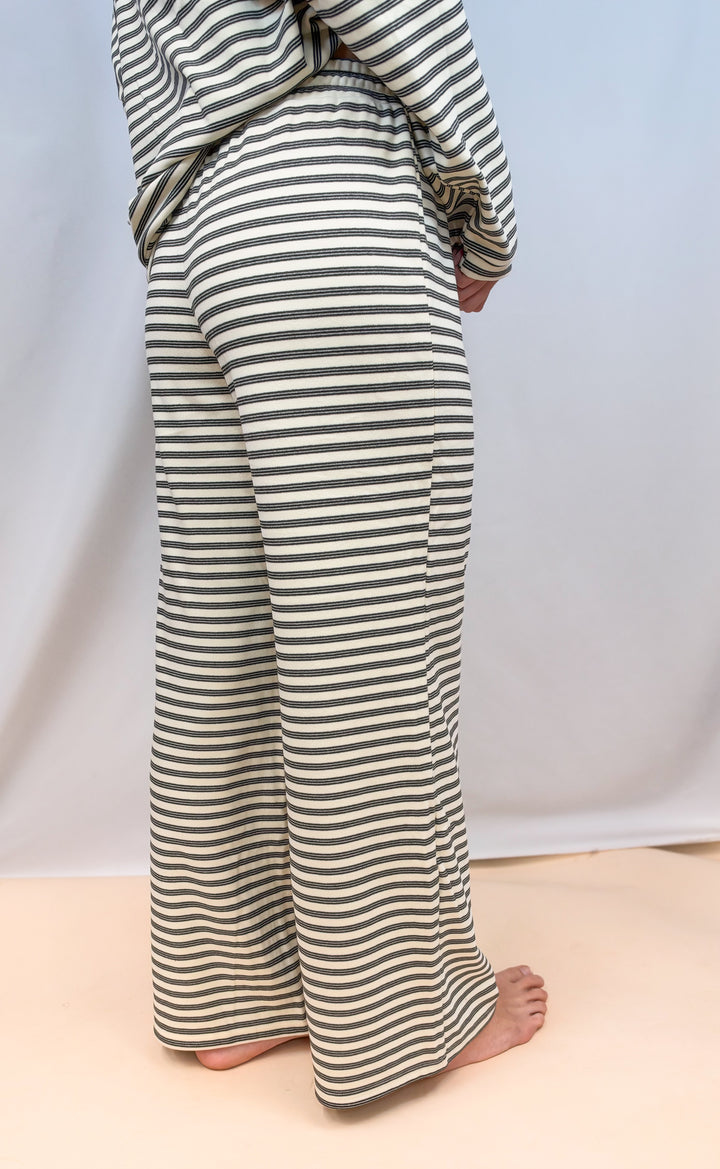 Woman shown from waist down wearing cream stripe matching set on plain background