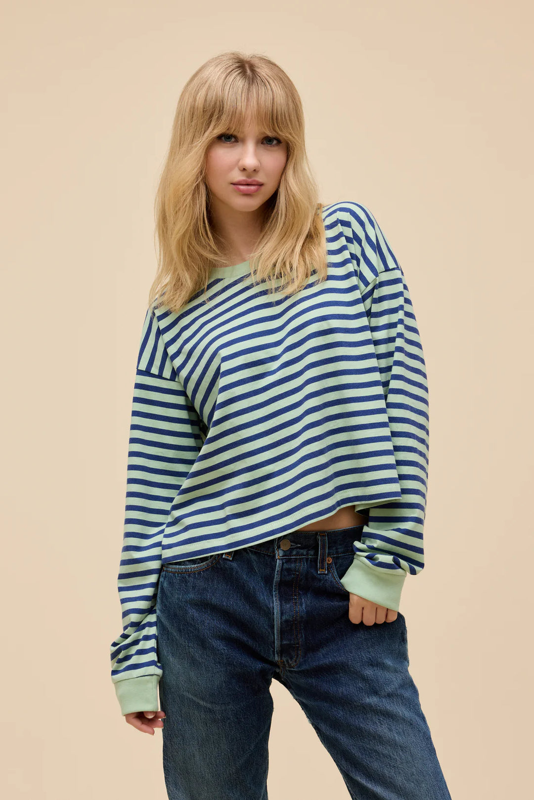 Woman wearing stripe long sleeve in front of plain background