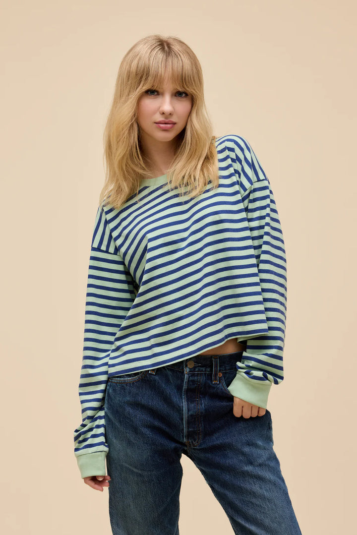 Woman wearing stripe long sleeve in front of plain background
