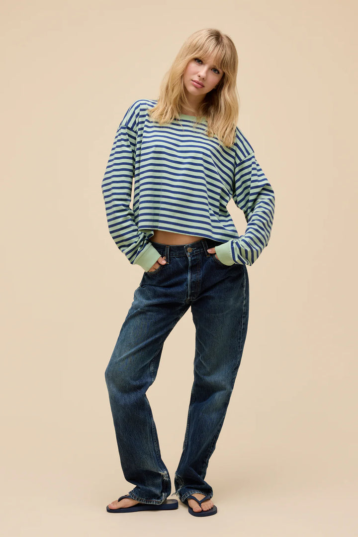 Woman wearing a striped sweater and jeans on a beige background