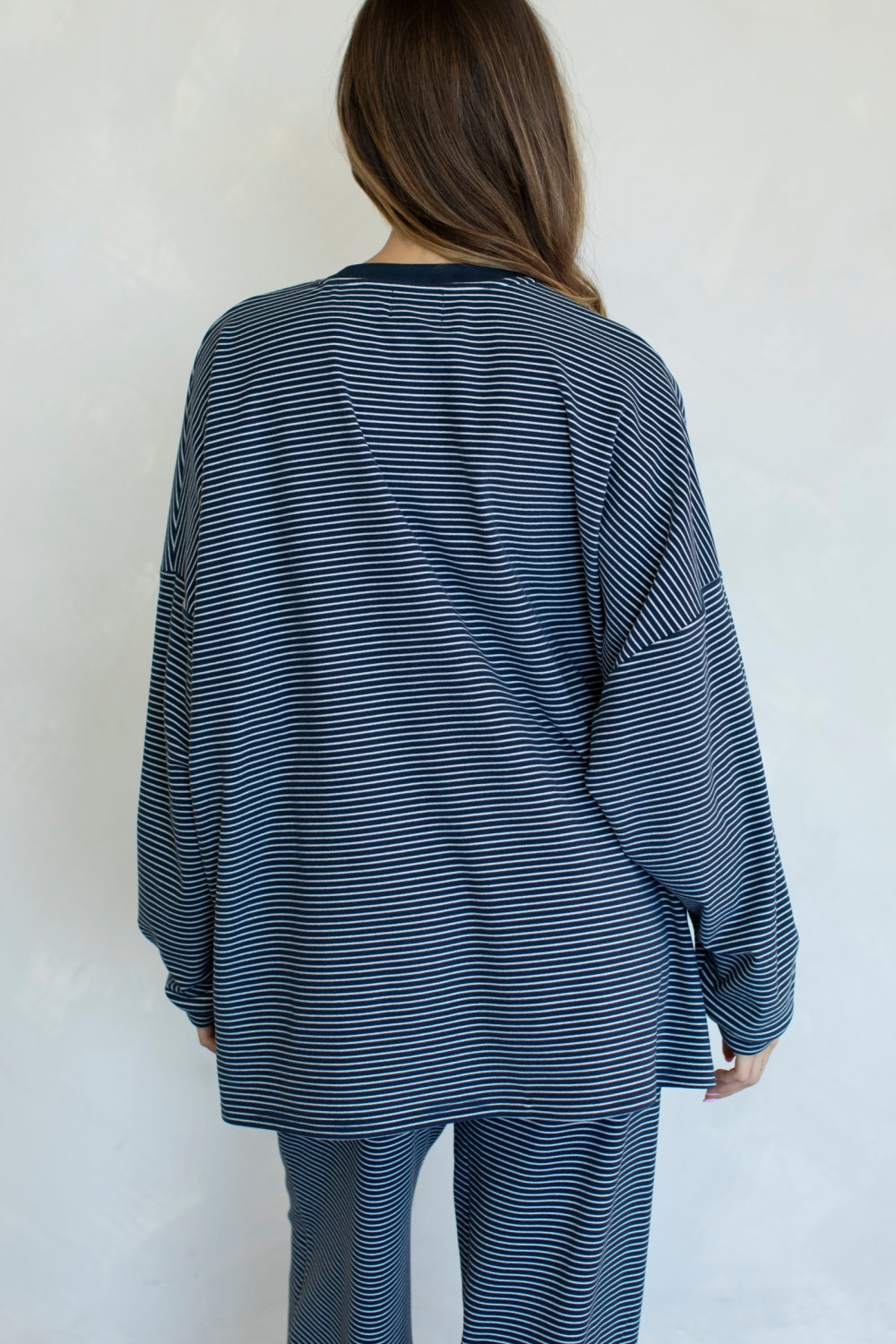Person wearing a blue and white striped outfit against a plain background