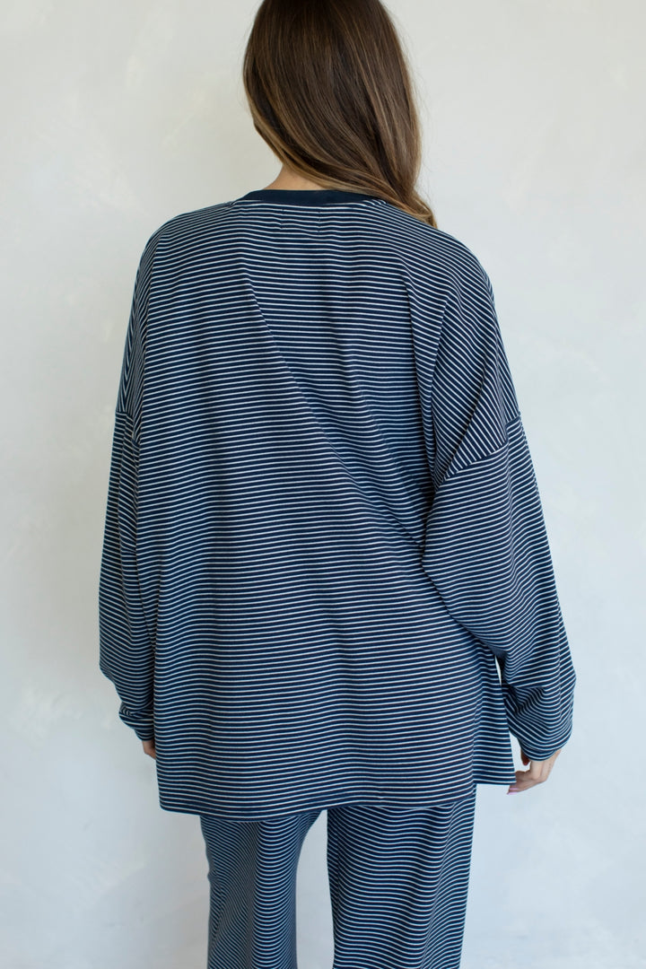 Person wearing a blue and white striped outfit against a plain background