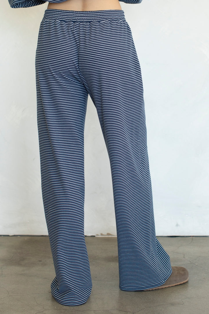 Blue striped pants worn by a person on a plain background