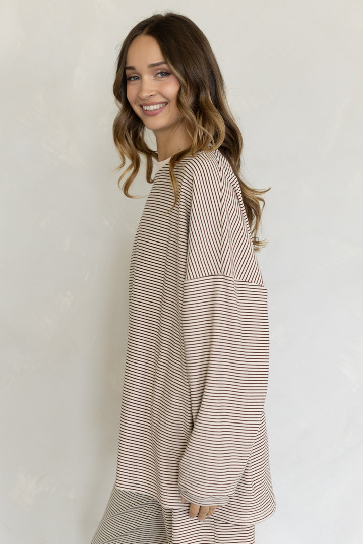 Woman wearing a striped dress against a plain background