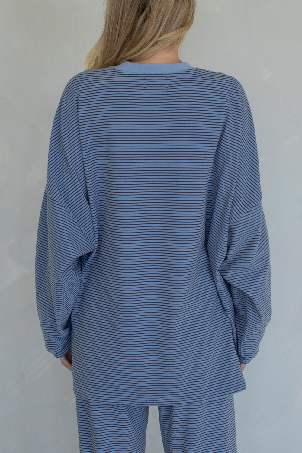 Person wearing a blue striped outfit against a plain background